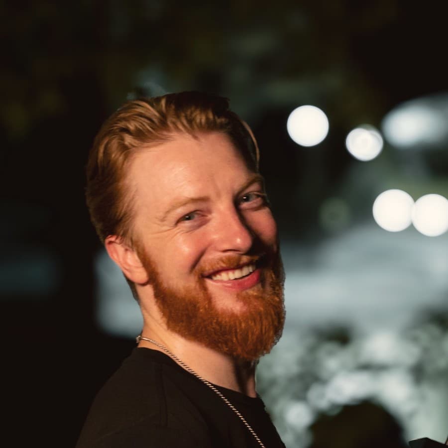 Kyle Redstone smiling, holding a cinema camera rig on a night street